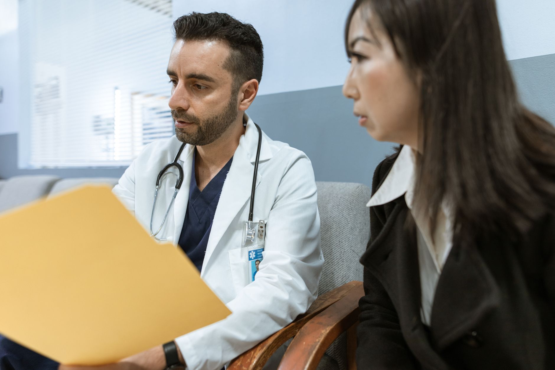 Médico e paciente conversam sobre um documento durante o atendimento.